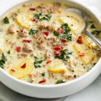 Zuppa Toscana Soup in a white bowl with sausage, potatoes, and kale.