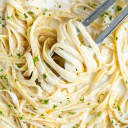 Fettuccine tossed in homemade Olive Garden Alfredo Sauce with fresh parsley on top.