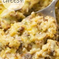 An image of cheesy beef and rice casserole in a casserole dish with a spoon scooping it up.