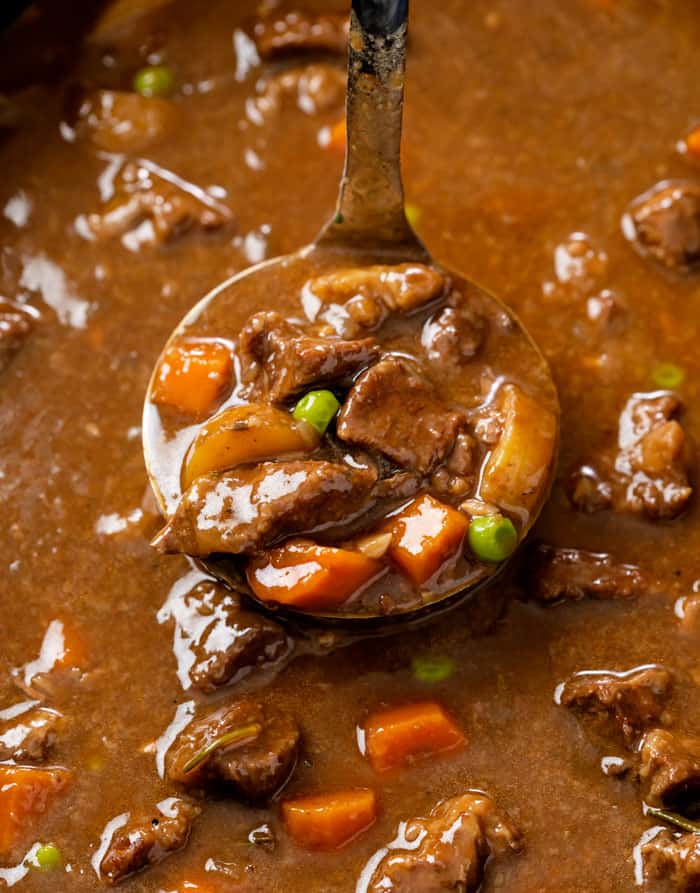 A ladle scooping Beef Stew up from a Slow Cooker.