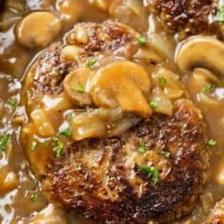 Salisbury Steak in a skillet with mushroom gravy and a label on top.