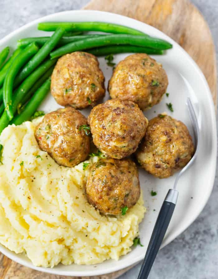 Turkey meatballs on a plate with mashed potatoes and green beans.