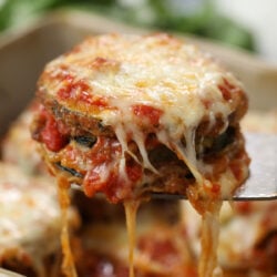 Zucchini Parmesan being held up with a spatula.