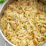 A skillet filled with Angel Hair Pasta with Chicken in a Parmesan Cream Sauce.