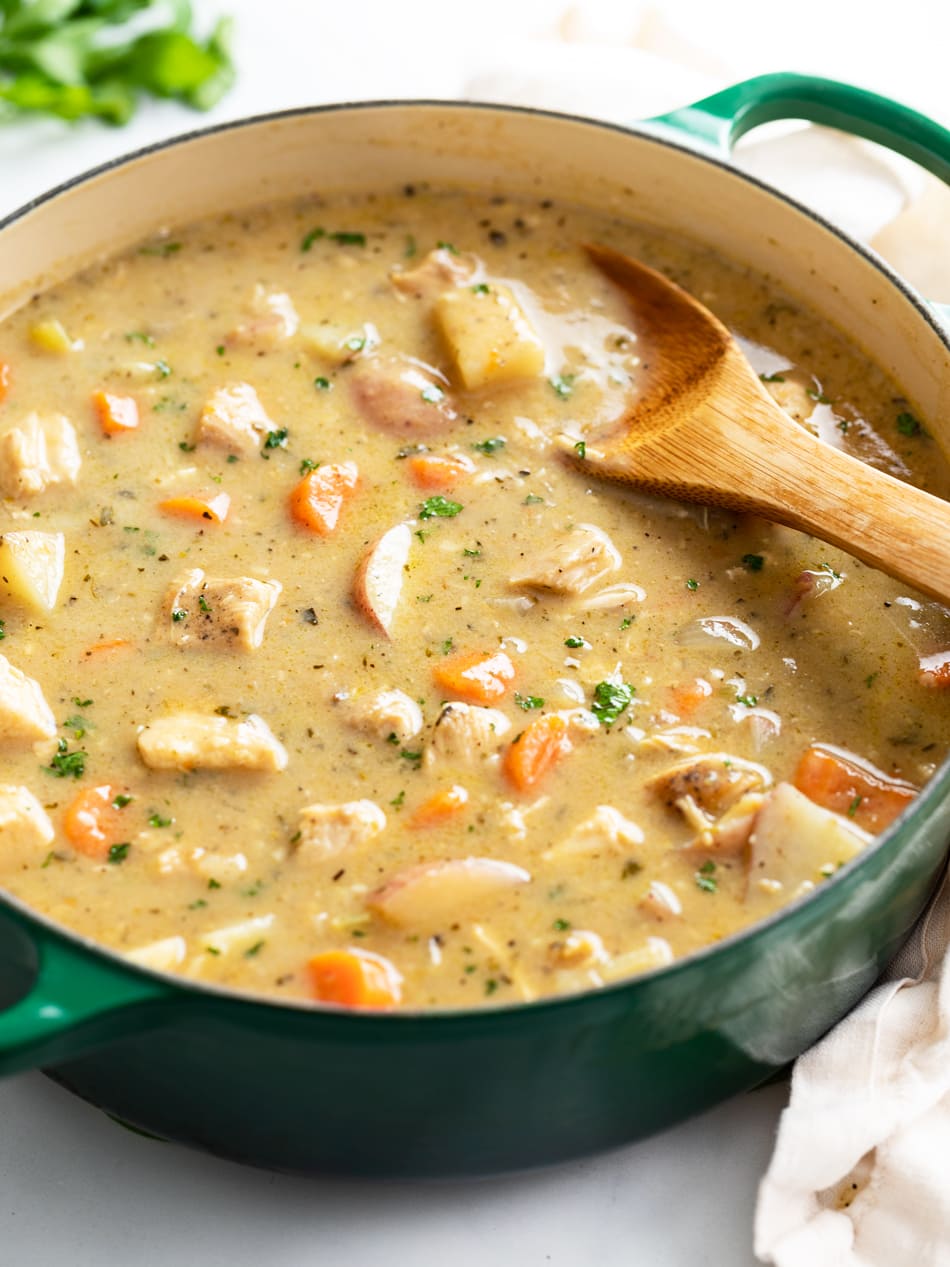 Chicken Stew in a soup pot with a wooden spoon.