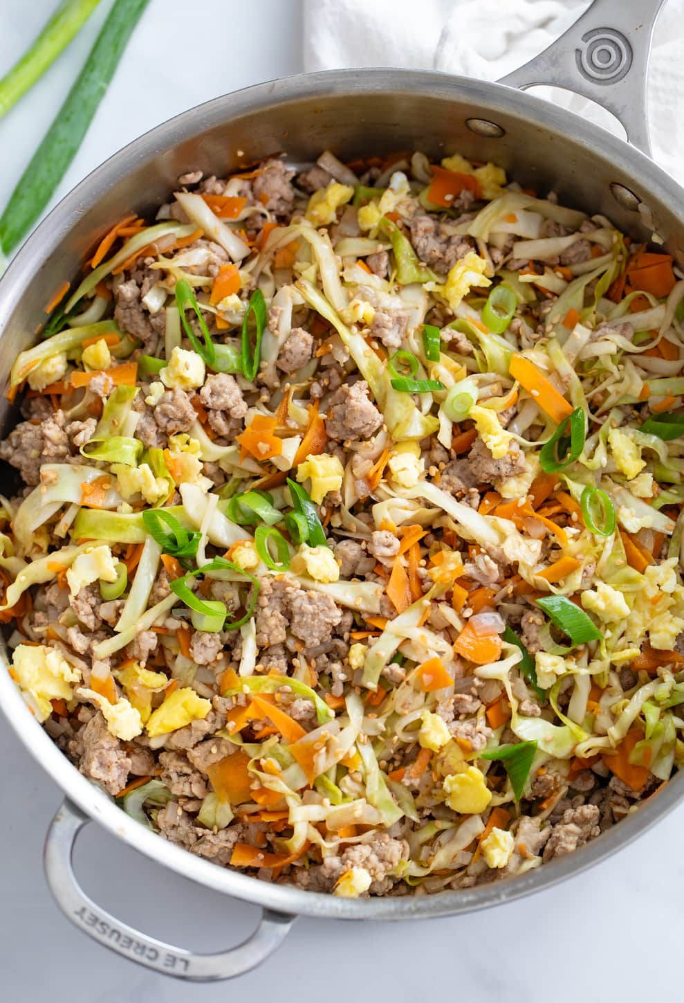 A skillet filled with Egg Roll in a Bowl with cabbage, carrots, pork, and scrambled eggs.