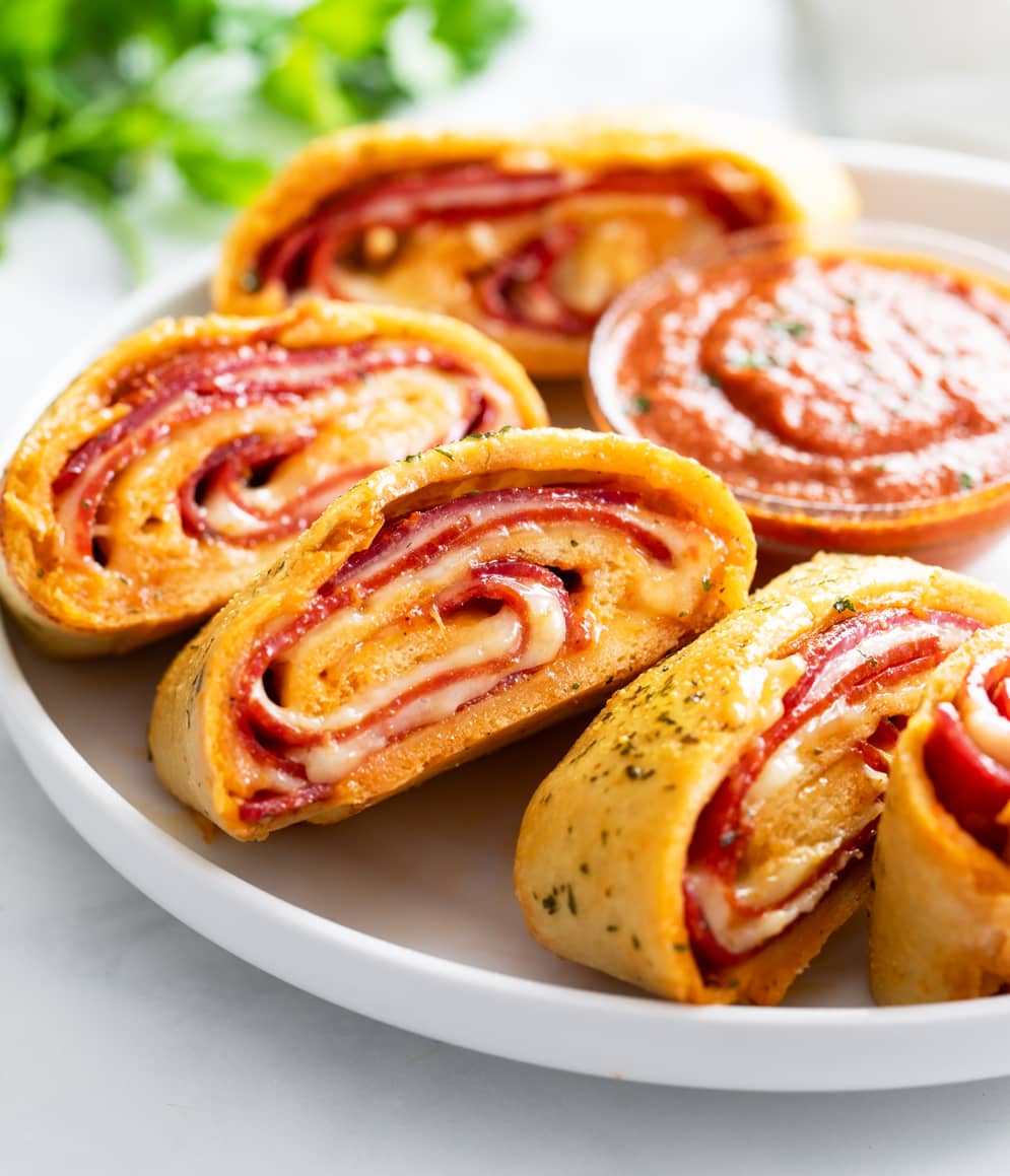 Slices of Stromboli on a white plate with parsley in the background.