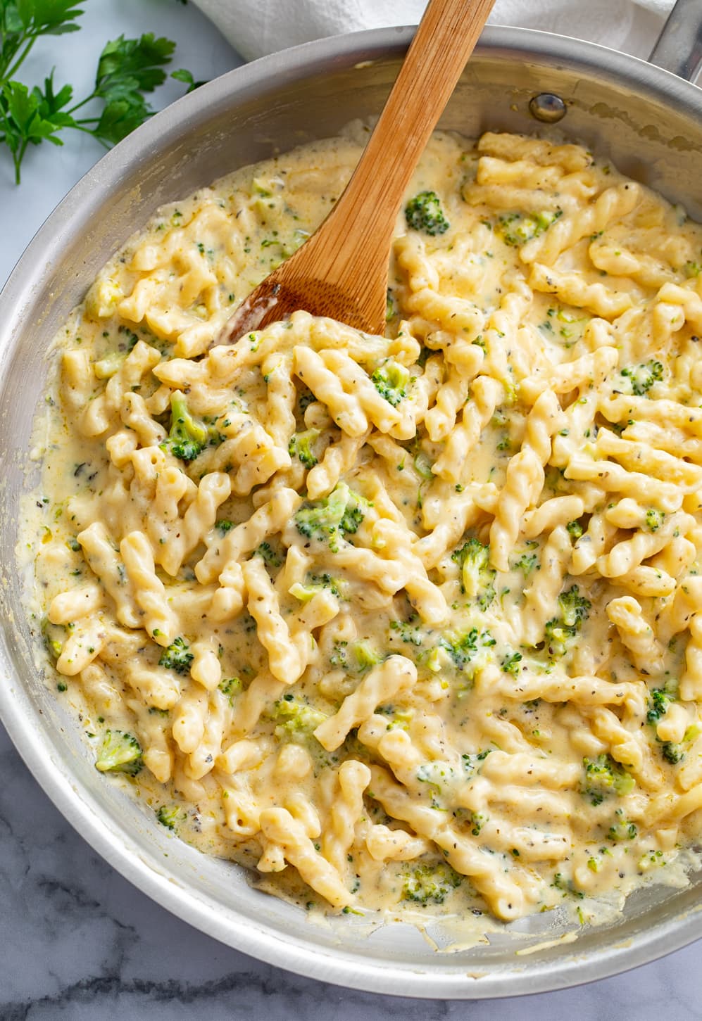 Cheese Pasta in a stainless steel skillet with a wooden spoon.