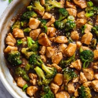 Teriyaki Chicken with broccoli in a brown teriyaki sauce in a skillet.