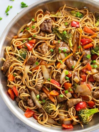 Beef Lo Mein in a skillet with brown sauce and vegetables.