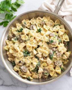 Mushroom Chicken Pasta in a skillet with spinach and a cream sauce.