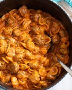 Meatball Pasta in a Dutch Oven with a spoon on the side.