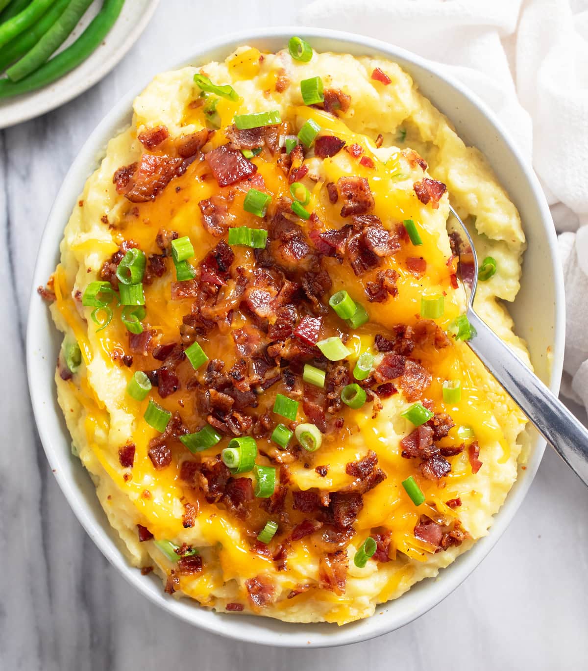 Overhead view of Loaded Mashed Potatoes with cheese, bacon, and green onions.